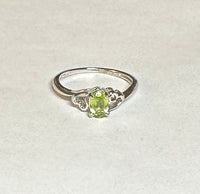 Sterling Silver Rhodium-plated Genuine Oval 6mm x 4mm Peridot Ladies Ring with Hearts